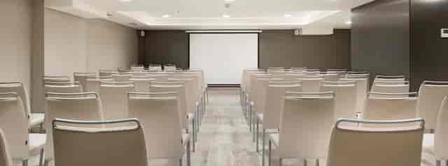 Modern meeting space with chairs and projection screen, ideal for workshops and presentations.
