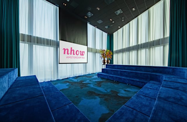 Modern meeting room in NH Hotel Amsterdam with tiered seating for corporate events.