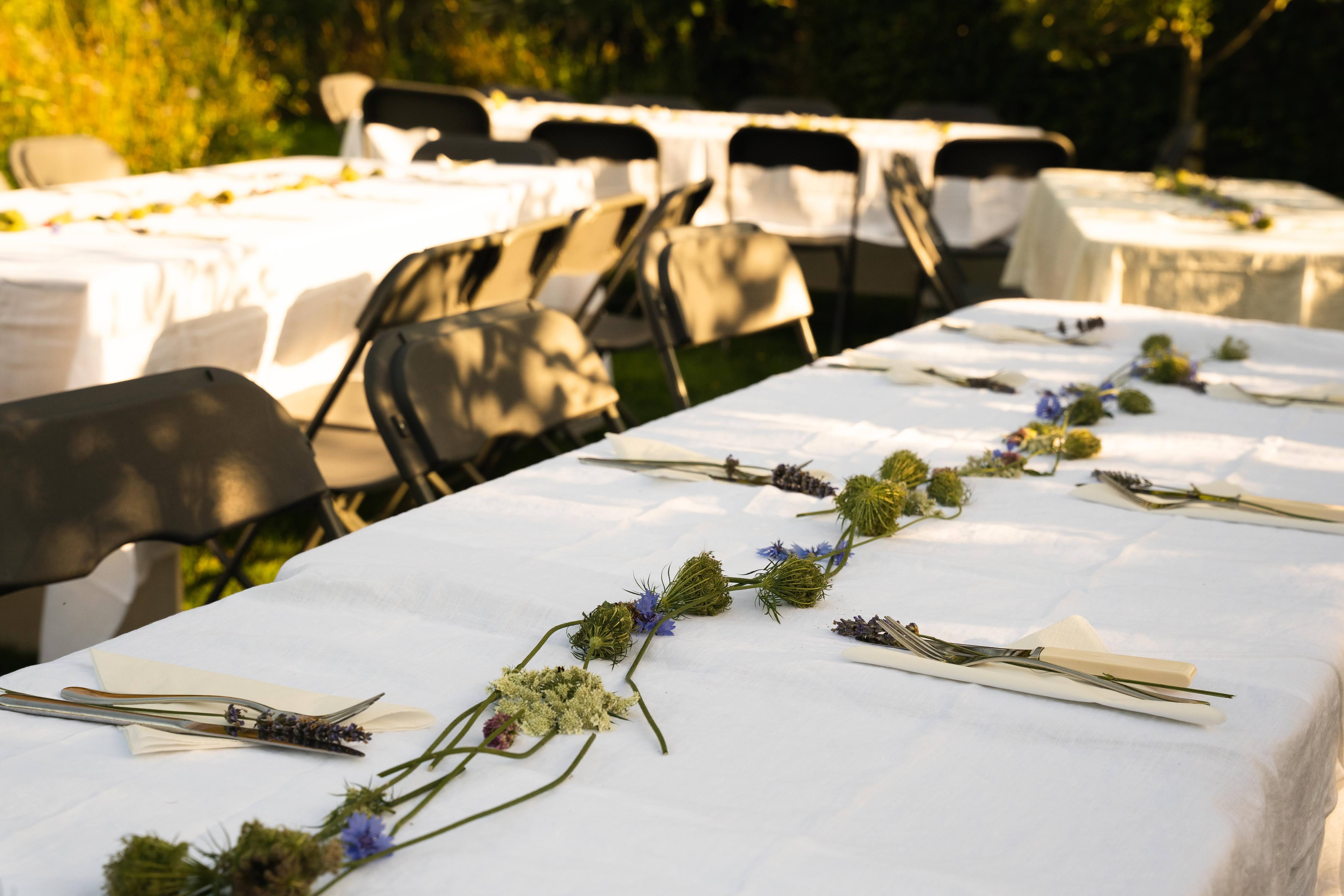 Elegant outdoor dining at Omved Gardens with floral centerpiece for events. - Banner