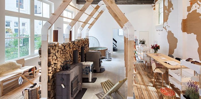 Modern event space with wooden structure and fireplace, perfect for meetings and workshops.