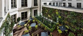 Vibrant outdoor meeting space with yellow chairs and vertical garden for networking events.