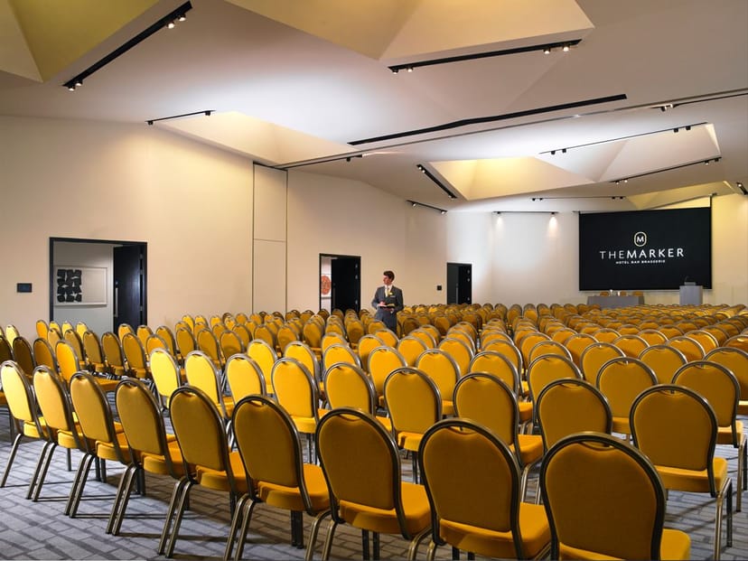 Spacious conference venue with yellow chairs at Anantara The Marker, perfect for workshops.