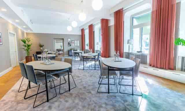 Modern meeting space with round tables, ideal for workshops and small conferences.