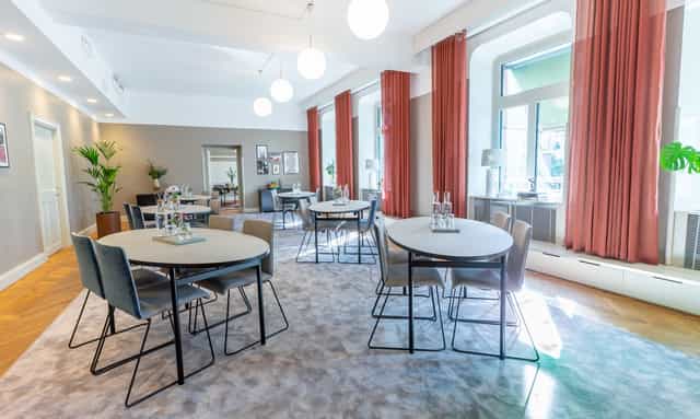 Modern meeting space with round tables, ideal for workshops and small conferences.