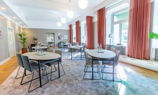 Modern meeting space with round tables, ideal for workshops and small conferences.