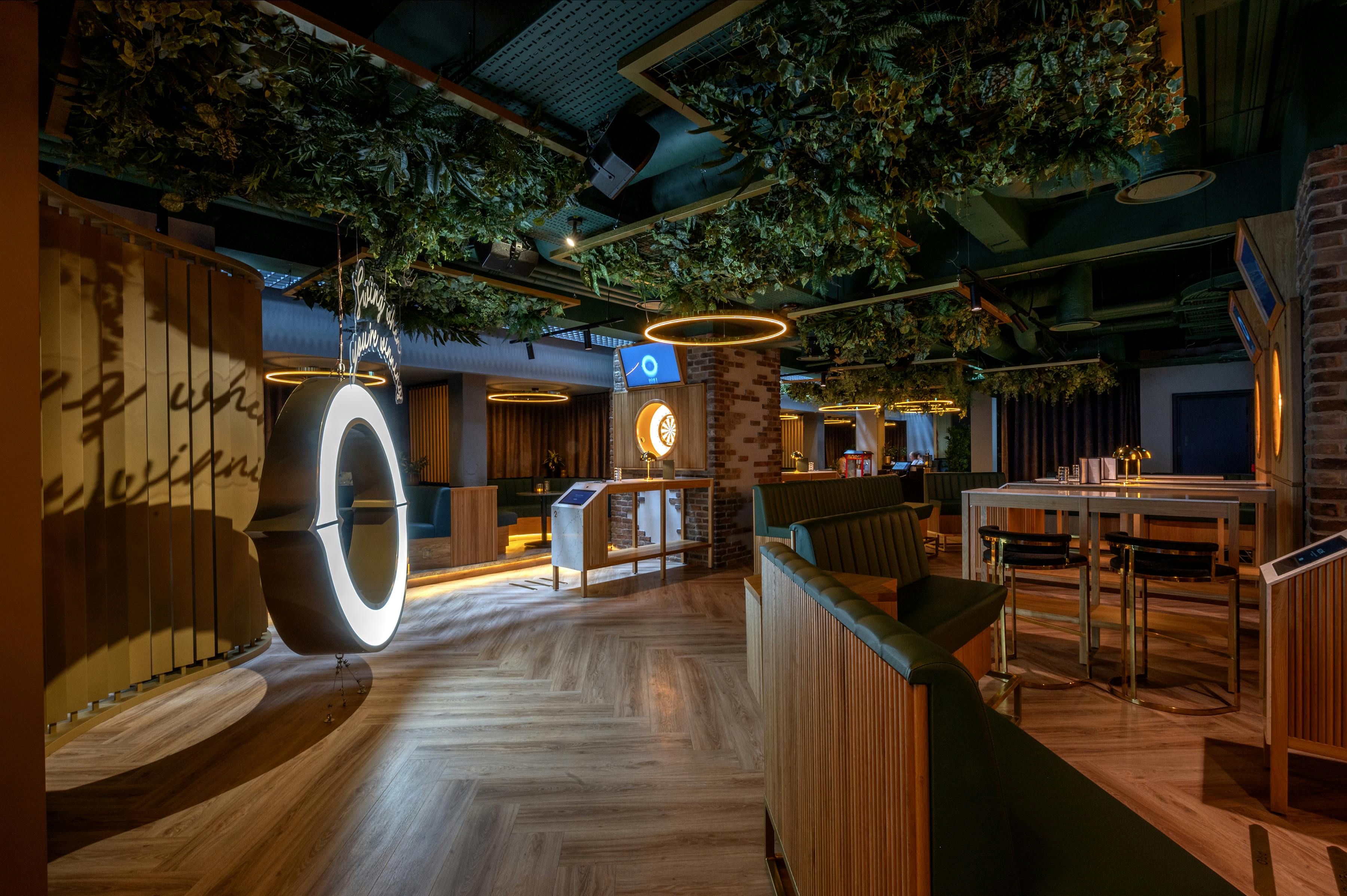 Modern event space in Göteborg Oche with lush greenery and circular lighting fixtures.