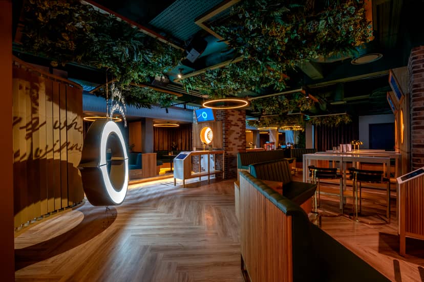 Modern event space in Göteborg Oche with lush greenery and circular lighting fixtures.
