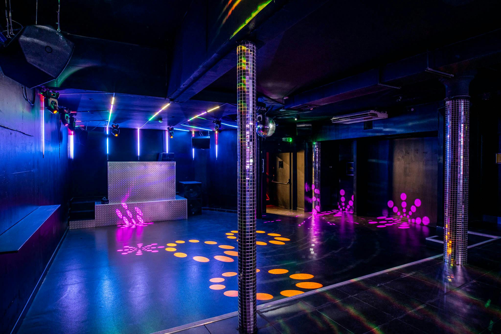 Modern event space in Manchester with sleek dark interior and vibrant lighting.