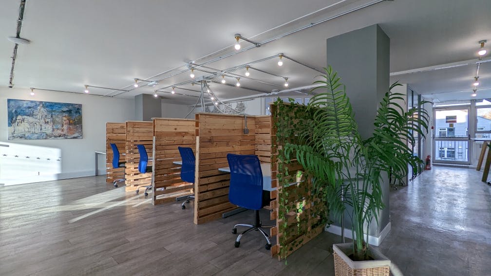 Modern hot desk workspace with wooden partitions in Chichester for collaboration and meetings.