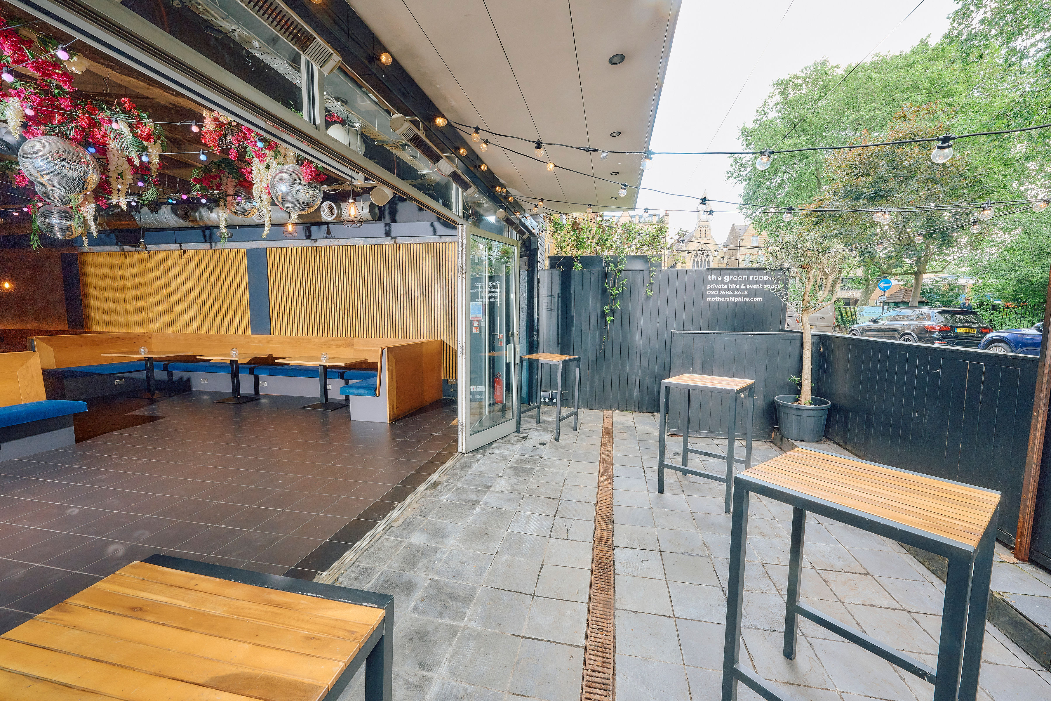 Versatile outdoor event space with modern high-tops, ideal for gatherings and networking.