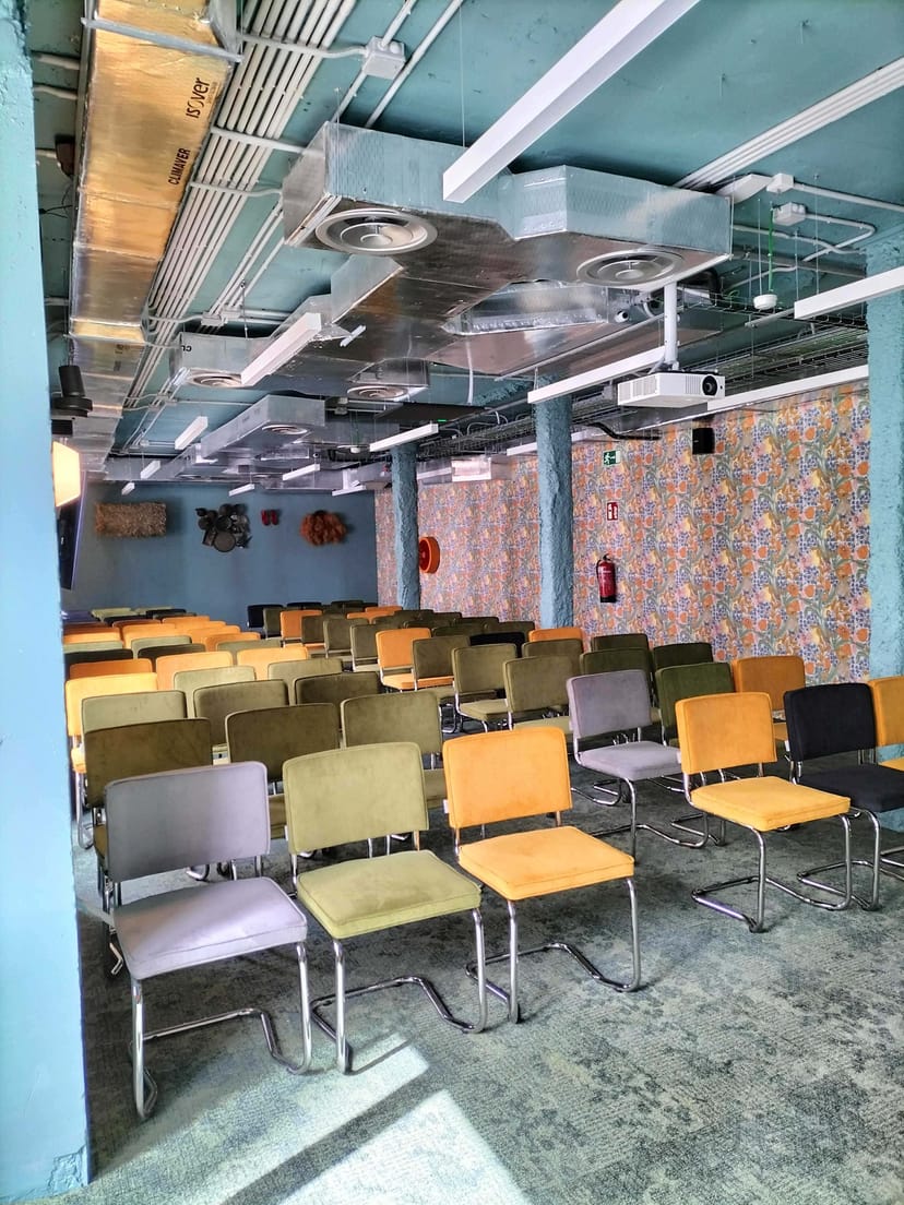 Versatile event space with colorful chairs, ideal for workshops and seminars.