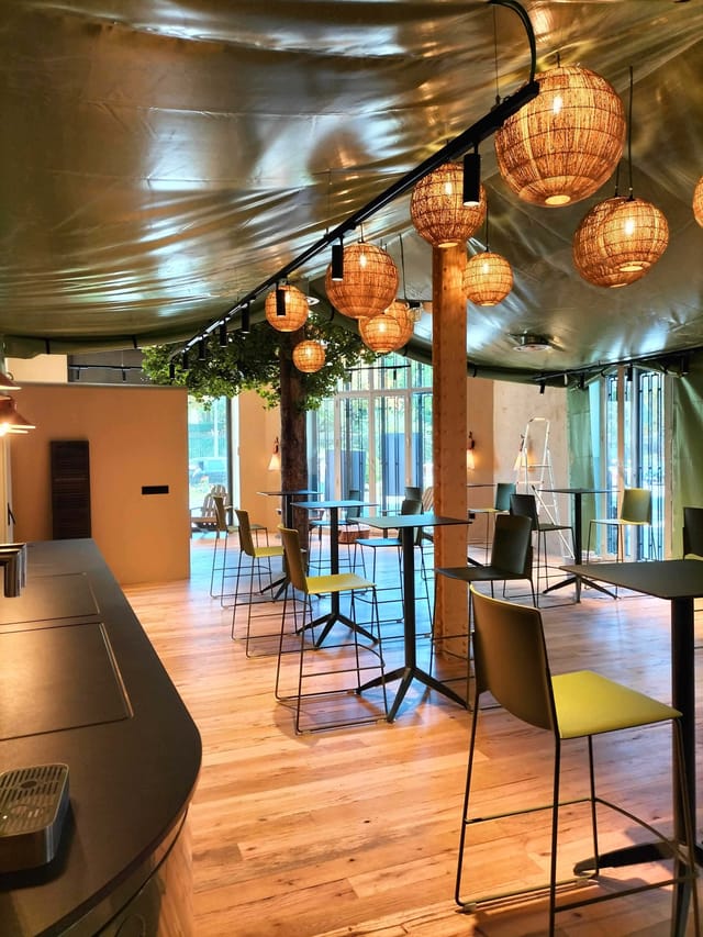 Versatile event space in Comet Retiro with warm lighting, ideal for networking and workshops.