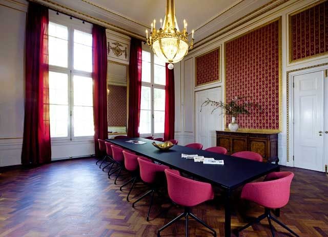Red Room in De Bary: elegant meeting space with black table and plush red chairs.