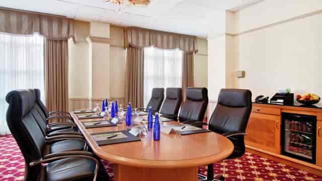 Hilton Pearl River meeting room with leather chairs, ideal for corporate events.