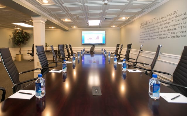 Conference room at The Olde Mill Inn with polished table, ideal for meetings and events.
