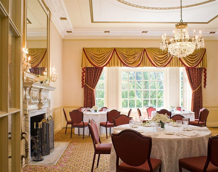 Elegant banquet room with chandelier for corporate events and intimate gatherings.