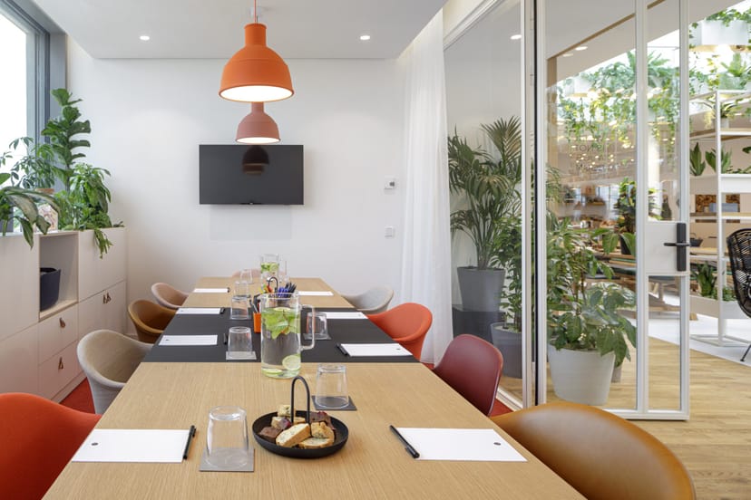 Modern meeting room in Zoku with wooden table, ideal for collaborative events and presentations.