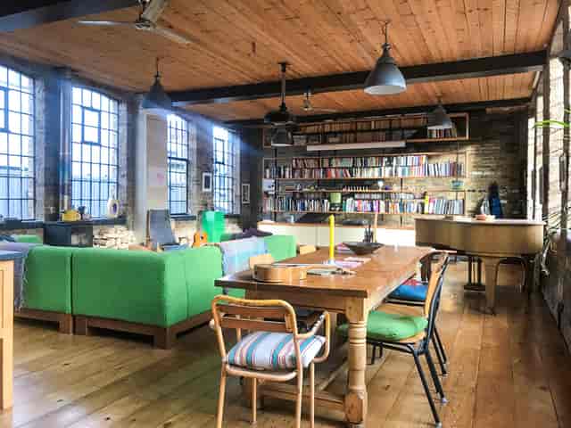 Stylish Shoreditch event space with green sofas, ideal for meetings and gatherings.