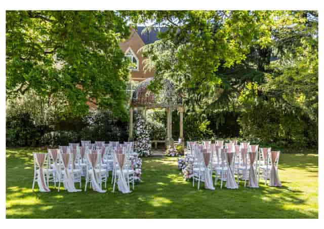 Edwardian Ballroom wedding setup with white chairs and pink sashes at Warren House Hotel.