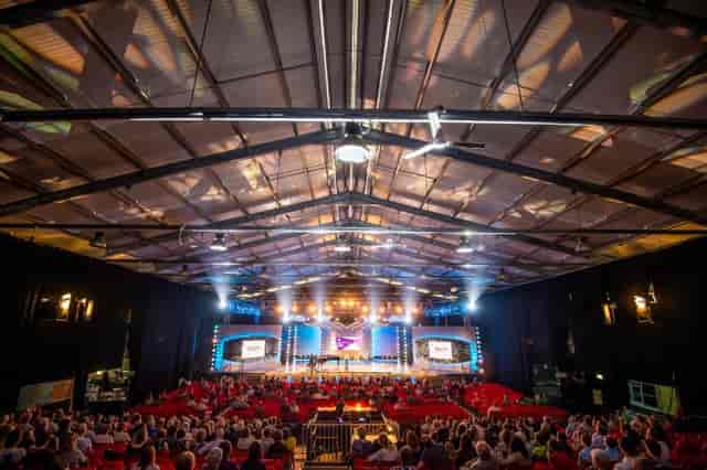 Royal Welsh Showground conference setup with tiered seating and vibrant lighting.