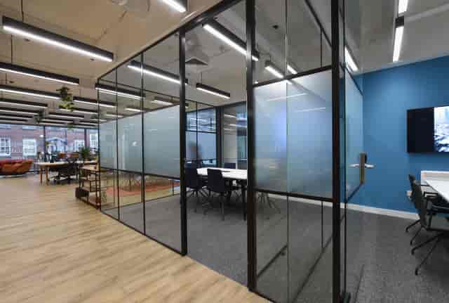 Modern meeting space with glass-walled rooms for collaborative events and brainstorming.