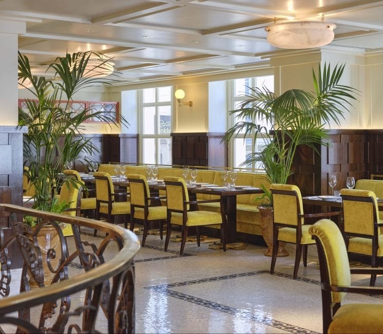 Stylish dining area with yellow seating at Drouant Restaurant for events and meetings.
