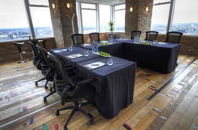 Modern meeting space with U-shaped table, natural light, ideal for corporate events.