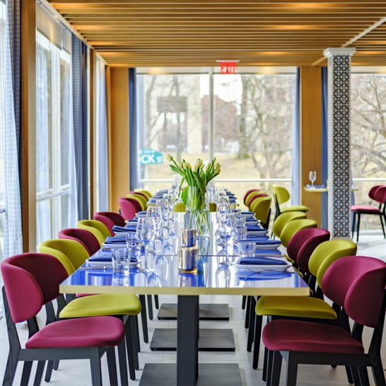 Private dining room in Positano Coast with vibrant chairs for corporate events.
