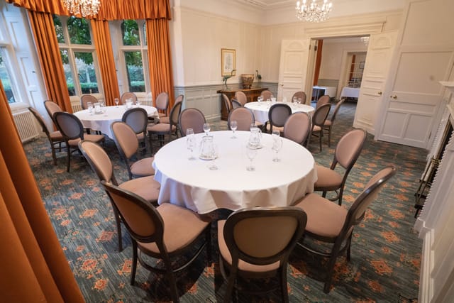 Elegant meeting room with round tables at Warren House Hotel, perfect for workshops and conferences.