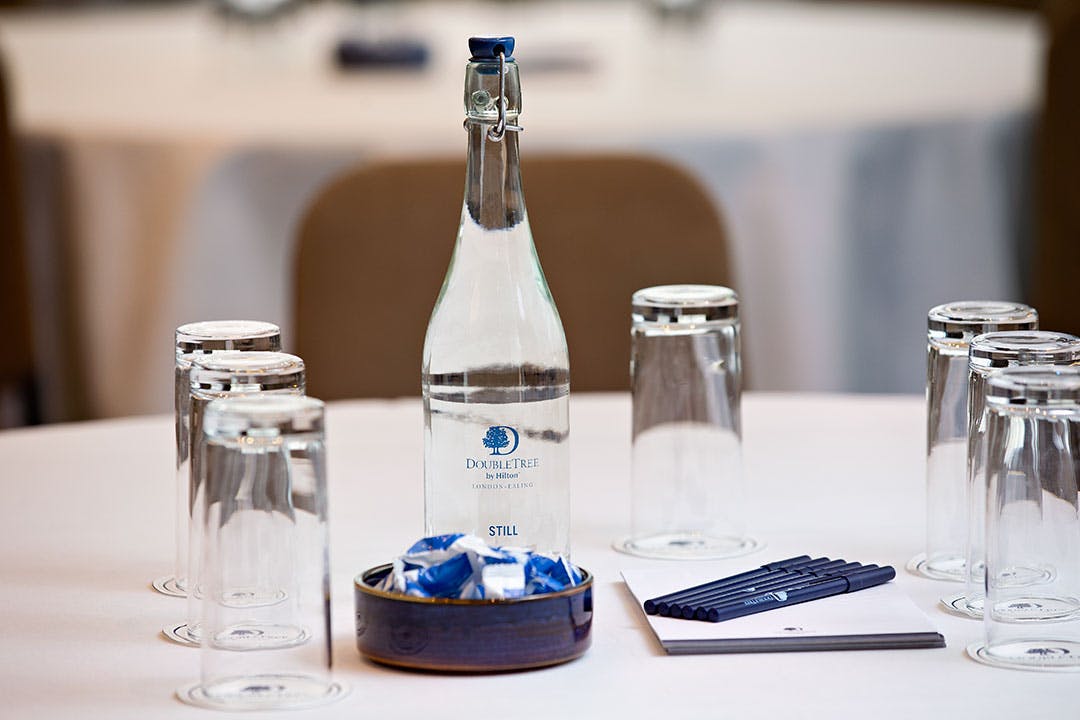 Ealing Suite meeting table with elegant water bottle, ideal for corporate events.