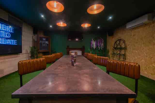 Modern meeting space with industrial table and greenery at The Potting Shed, Swansea.