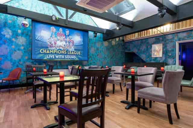 Intimate event space in Zebrano Soho with vibrant blue decor, ideal for gatherings.