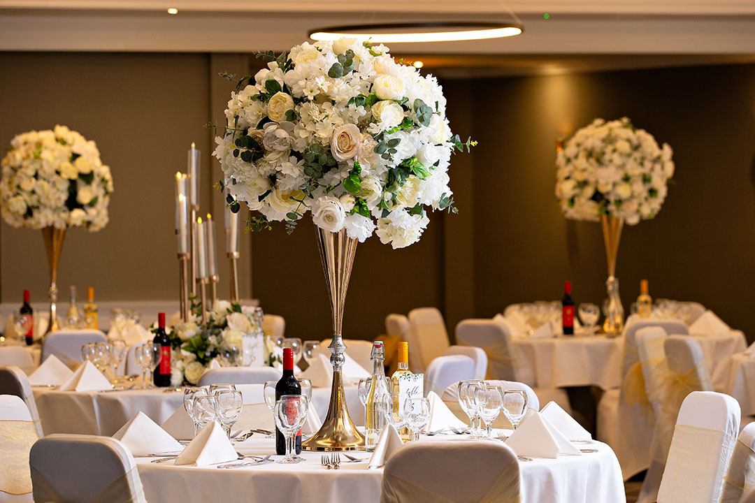 Elegant event space with floral centerpieces, ideal for weddings and gatherings.