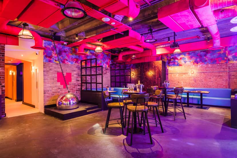 Vibrant event space at Lucky Voice Liverpool Street with exposed brick and colorful lighting.