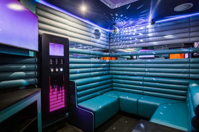 Vibrant karaoke room with turquoise seating for team-building and parties at Lucky Voice.