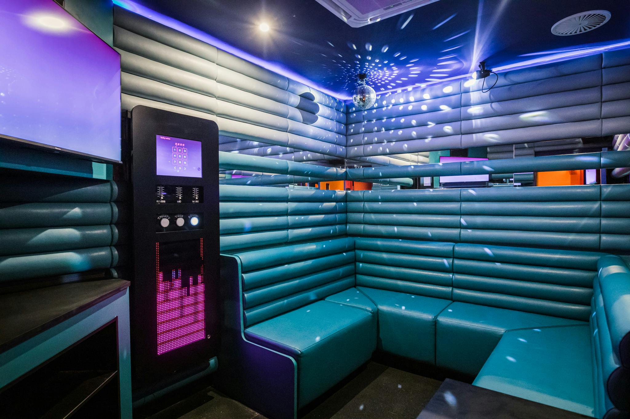 Vibrant karaoke room with sleek seating for team-building and parties at Lucky Voice Liverpool.