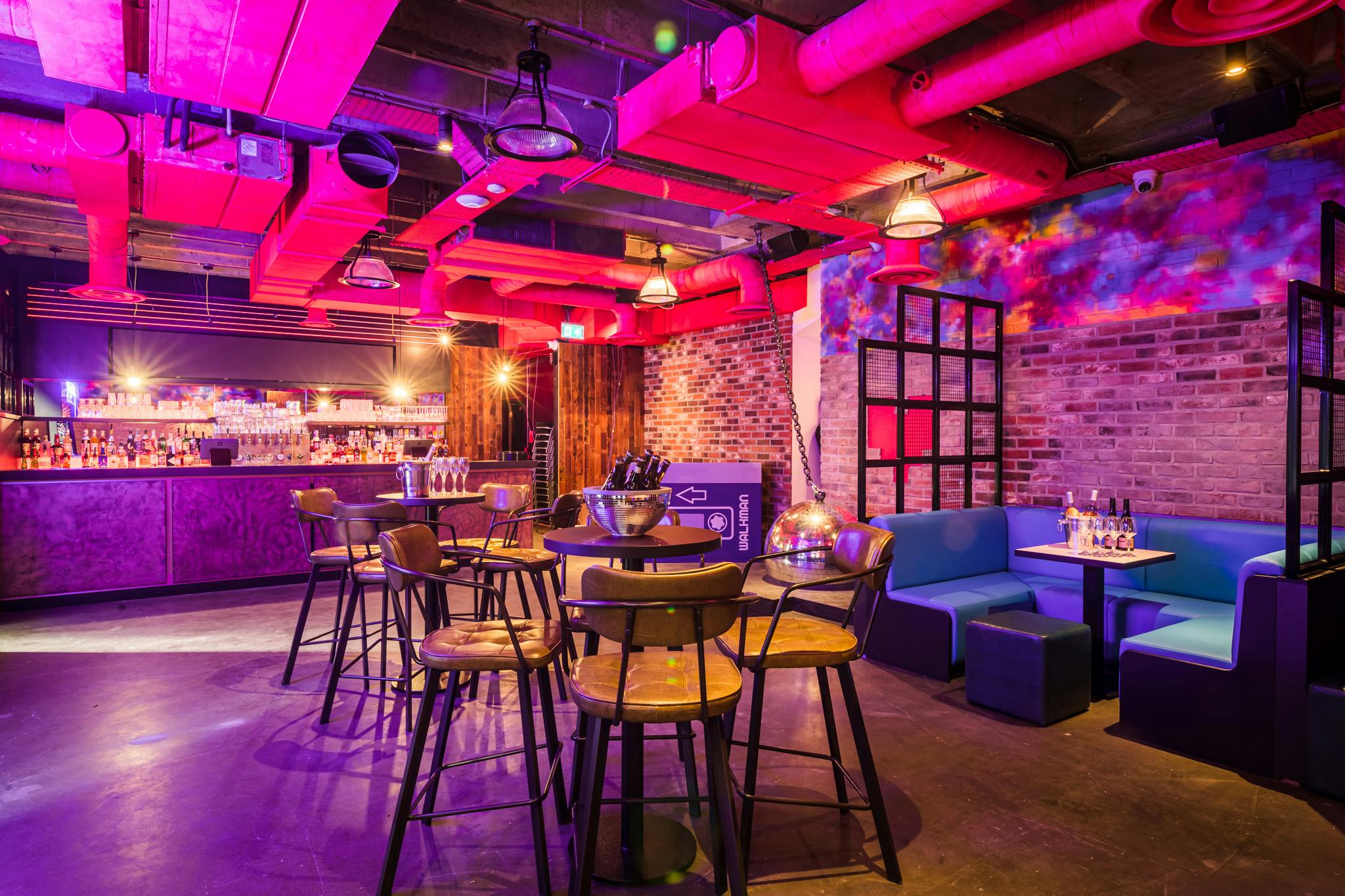 Vibrant event space at Lucky Voice Liverpool Street with modern decor and colorful lighting.
