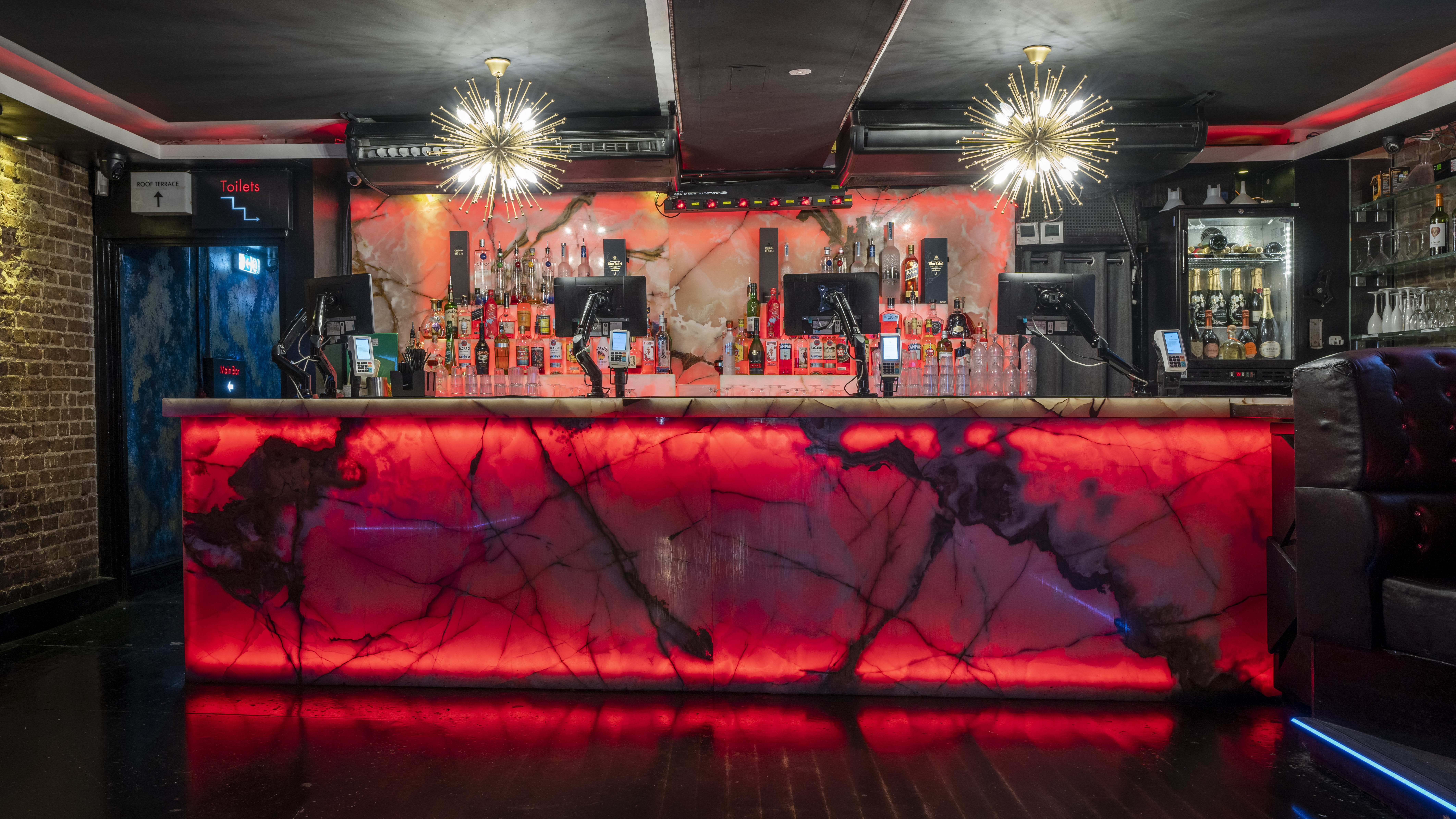 Modern bar with illuminated countertop at Zebrano Soho for vibrant events and gatherings. - Banner