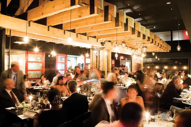 Vibrant dining event at The Shed in Blackbarn with warm lighting and wooden beams.