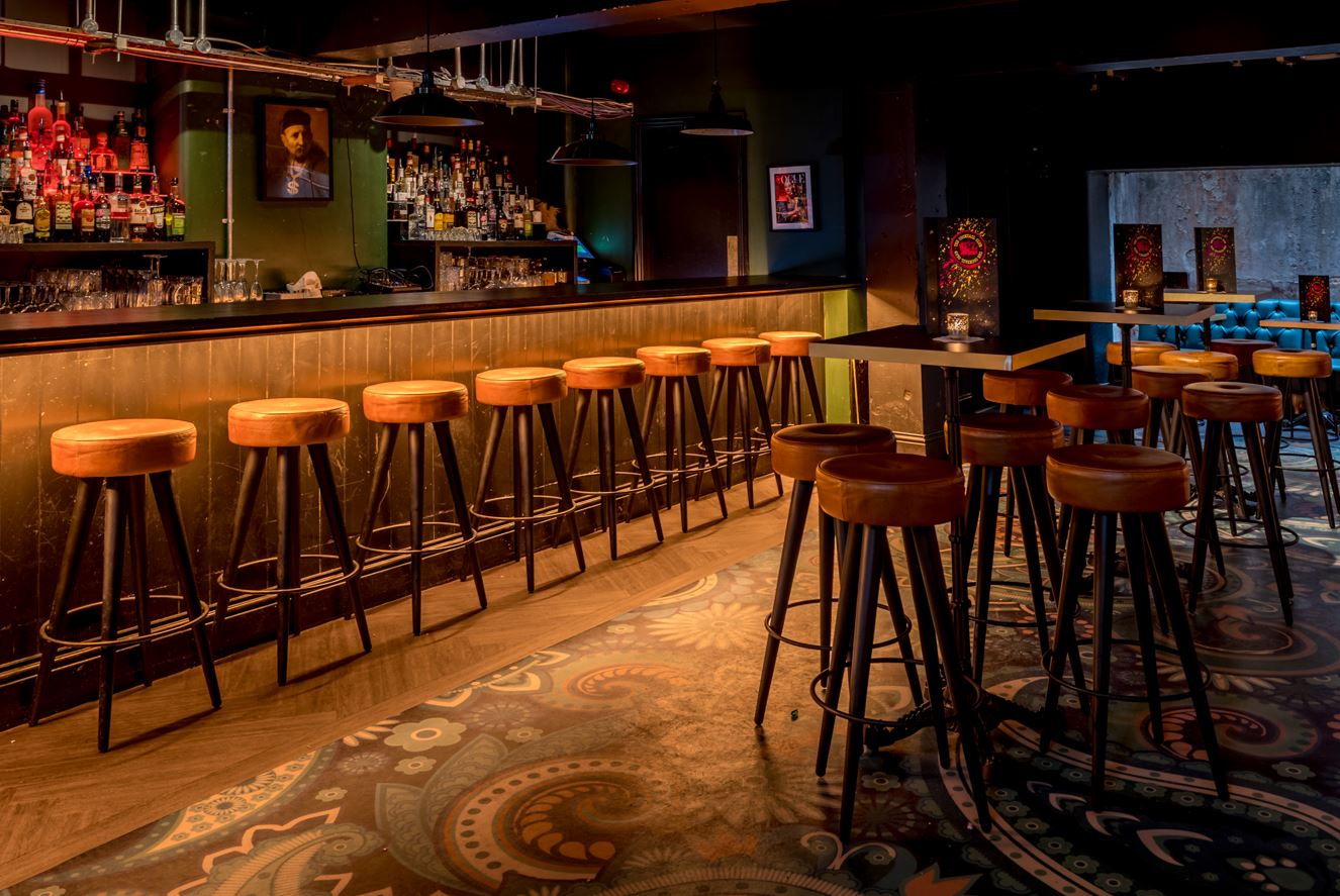 Stylish bar with wooden stools in The Cocktail Club Bristol, ideal for networking events. - Banner