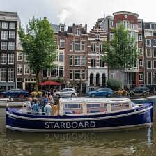 Private boats in Amsterdam canal for networking and team-building events.