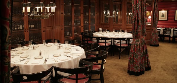 Elegant wine cellar dining space with round tables, perfect for private events and networking.