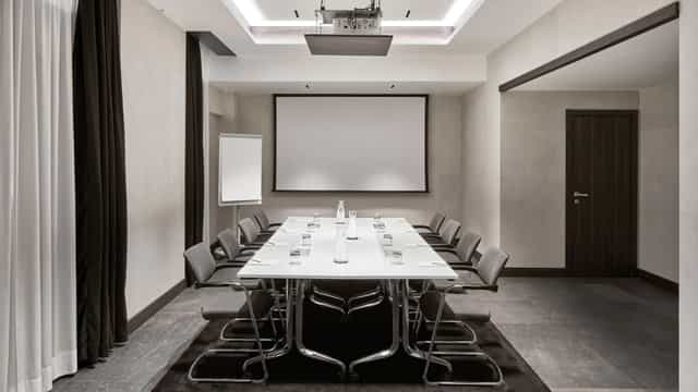 Modern meeting room at Hyatt Centric Milan with sleek table, ideal for conferences and events.