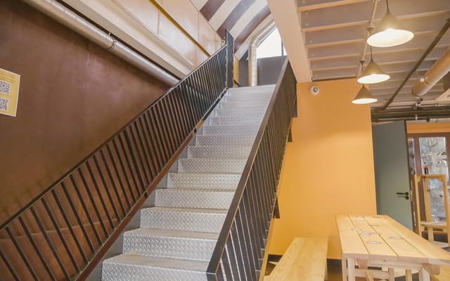 Well-lit staircase in modern industrial brewery, perfect for events and networking.