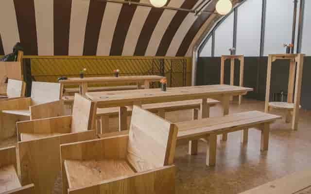 Modern event space with wooden furniture for workshops at Locks Industrial Brewery.