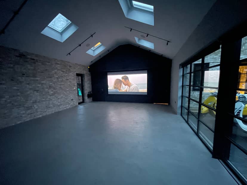 Versatile event space with large projection screen, ideal for presentations and workshops.