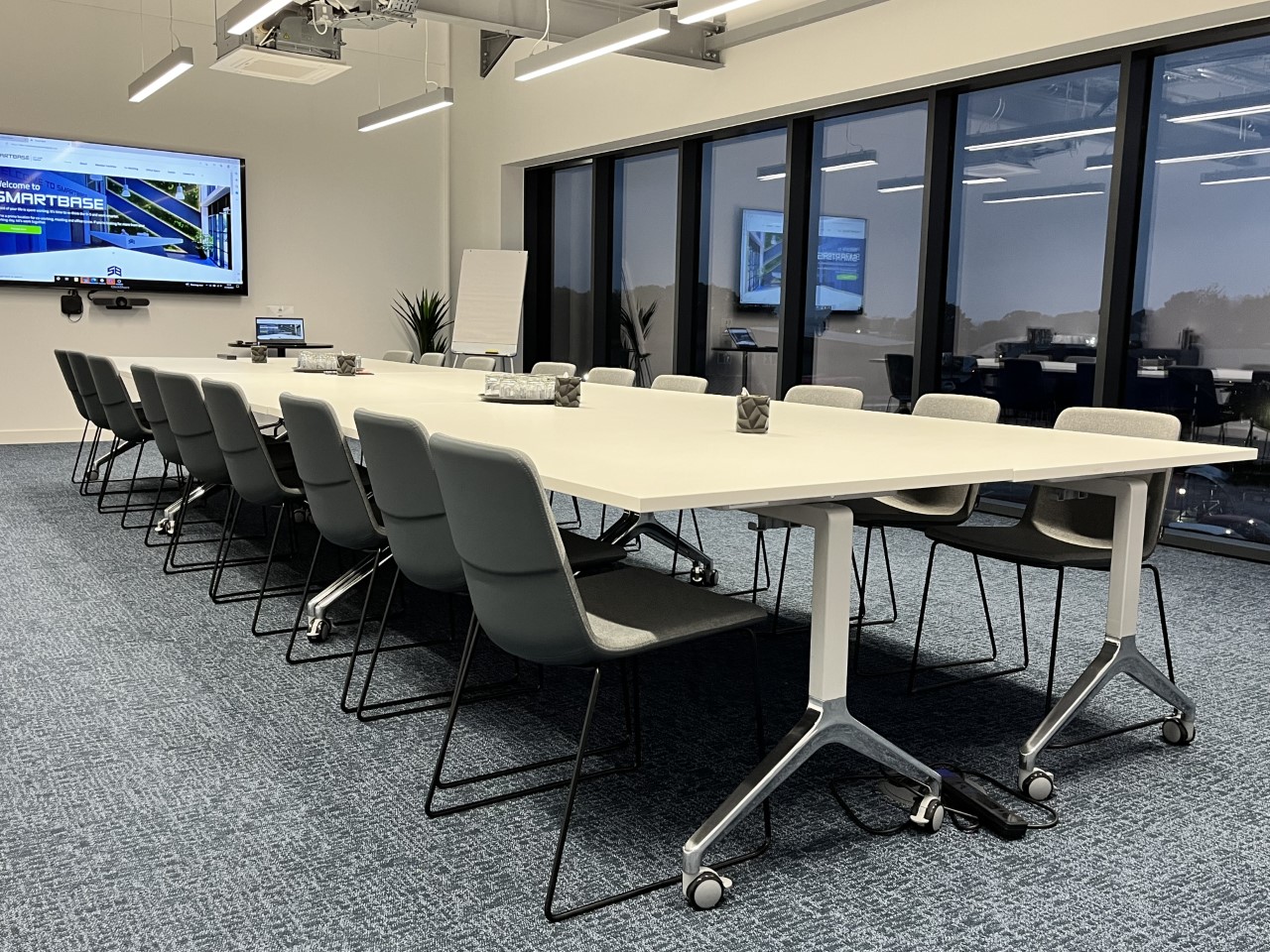 Modern conference room with sleek table, ideal for hybrid meetings and presentations. - Banner