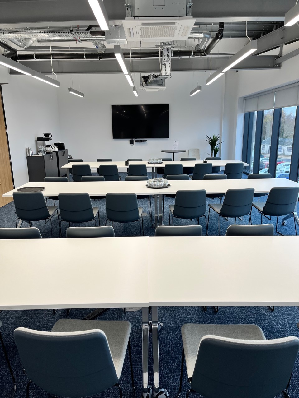 SmartBase meeting room with classroom tables, ideal for workshops and collaboration. - Banner