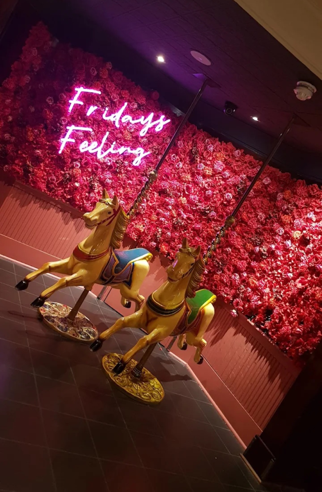 Vibrant event space with floral backdrop and carousel horses in Glasgow for themed gatherings. - Banner