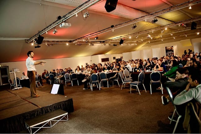 Corporate event at Thorpe Park with speaker engaging audience in a spacious venue.